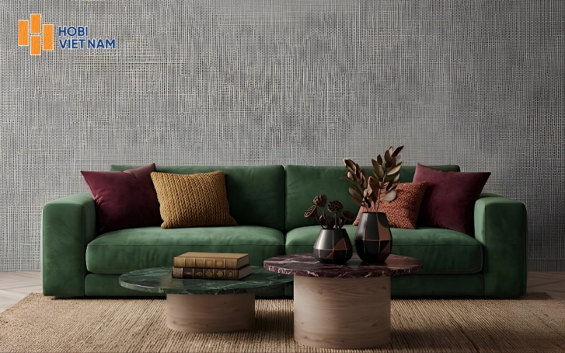 Giấy dán tường giả vải xám nổi bật bên ghế sofa nhung xanh