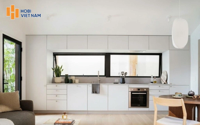 Tủ bếp chữ I màu trắng thiết kế ôm trọn cửa sổ lấy ánh sáng tự nhiên